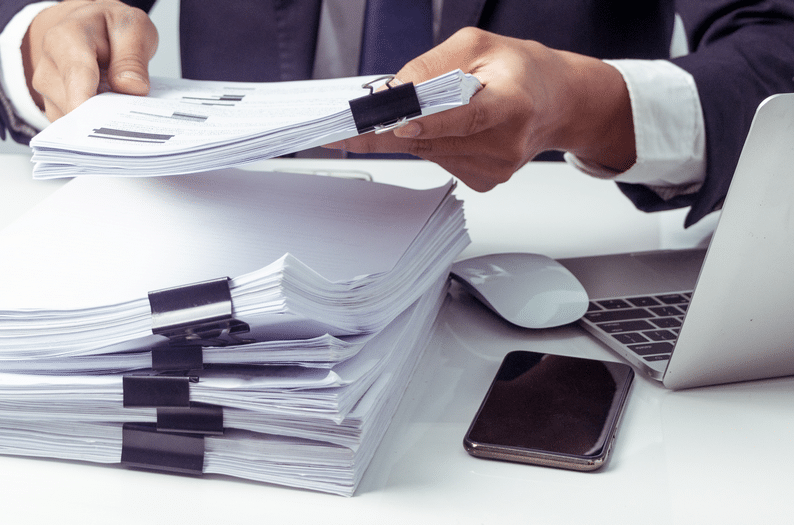 Photograph of a pile of documents needed for initial applications and amendments consulting